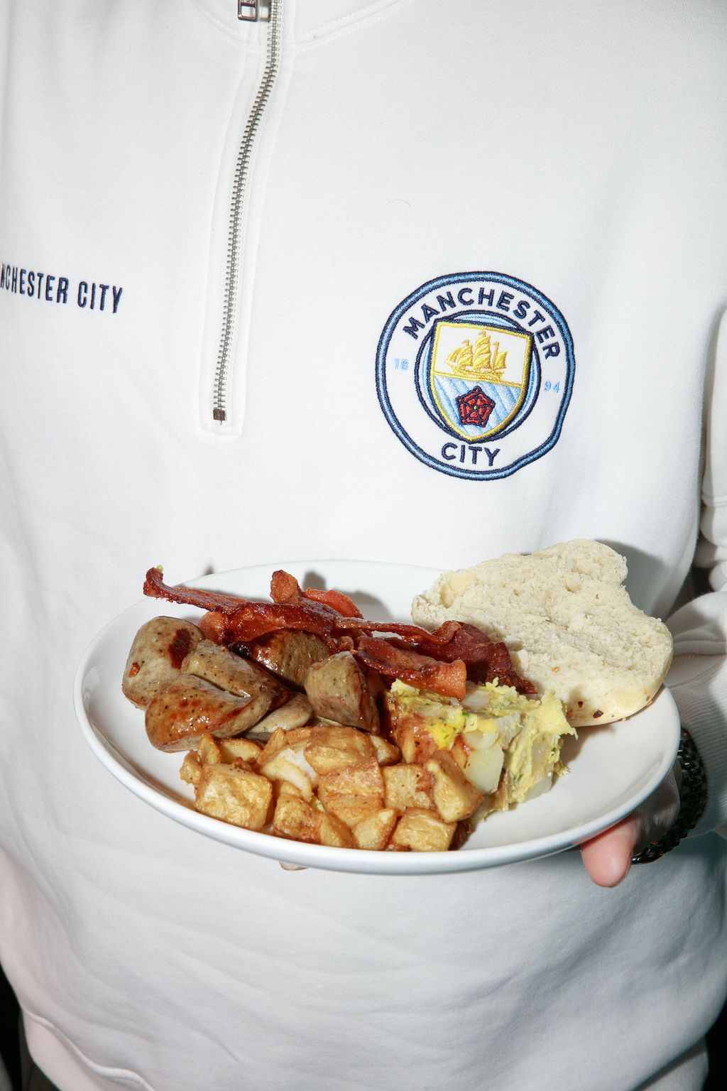 Brunch plate held in front of a Manchester City jersey