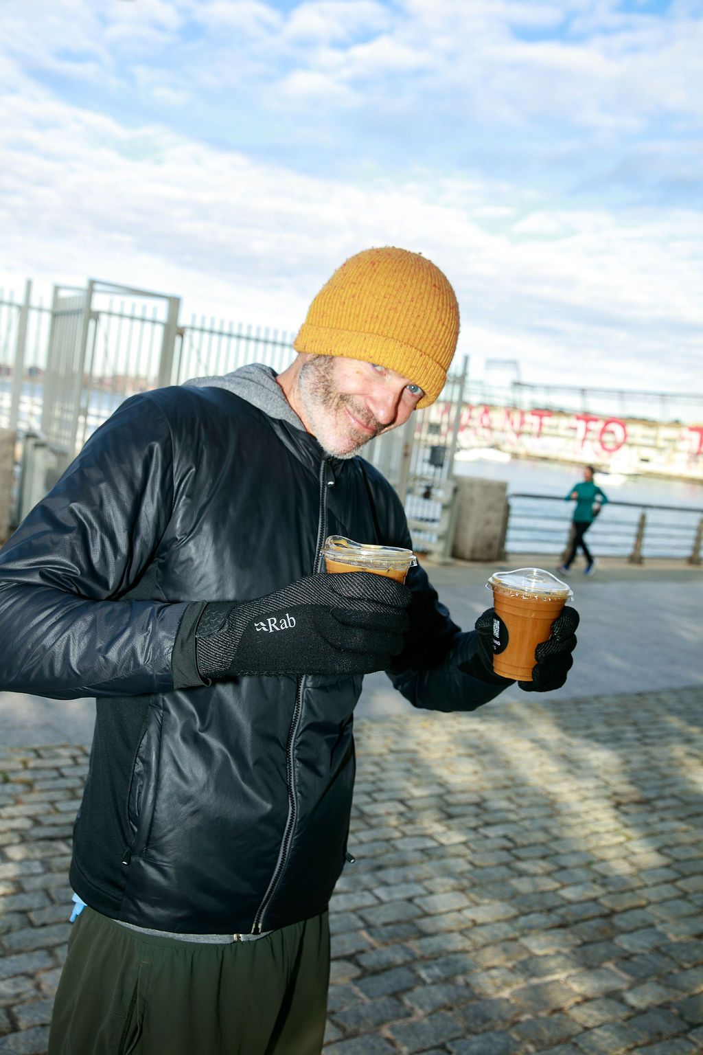 Guest in a yellow beanie enjoying coffee outdoors